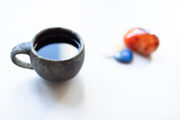 Cup of tea or coffee on white table with crystal stones. Relaxation time, mindfulness, meditation.