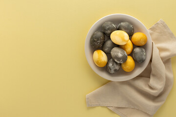 Golden and silver easter eggs in a plate isolated on yellow background