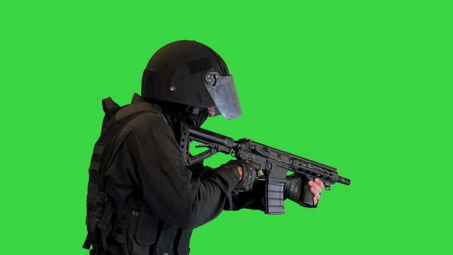 Police anti terrorism squad fighter shooting from rifle on a Green Screen, Chroma Key.