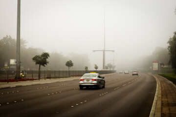 Dubai roads in a foggy weather. United Arab Emirates motorist maintaining safe distance due to poor visibility