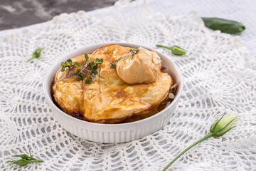 An individual serving of apple pie with ice cream in bowl on the table
