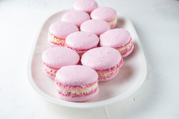 French macaroni cakes on a white oval plate on a light background