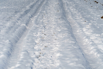 Fototapeta na wymiar Fahrzeug Spuren in einem verschneiten Acker im Winter