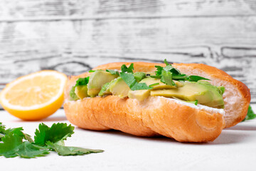 Sandwich with avocado and cream cheese on the white table