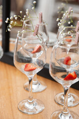 Wineglasses with strawberries, ibright background, red accent.