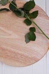 łodyga róży z liśćmi na drewnianej desce