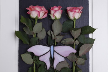 Róże różowe i różowy szklany motyl