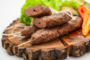 Lamb kebabs on serving board with vegetables