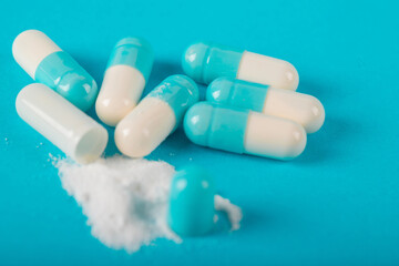 Blue and white capsule pills on blue background. Antibiotics drug resistance. Antimicrobial capsule pills. Pharmaceutical industry. Healthcare and drugstore. Pharmaceutics concept. Drug in hospital. 