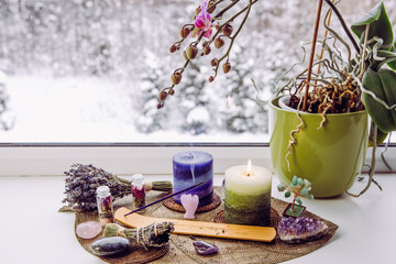 Small good feng shui altar in home on window sill on leaf shape table mat, snowy Nordic nature on...