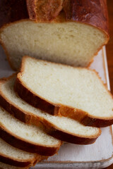 Sweet bread and slices of bread on a wooden table.