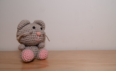 Gatito tejido a mano sentado sobre mesa de madera