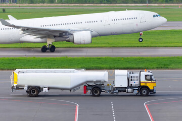 Truck with trailer tanker aviation fuel, airport services and airliner huge airplane take off.