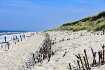 Idyllic dune landscape on the holiday island of Sylt with beach chairs and the North Sea at low tide