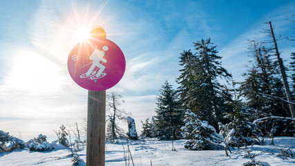 Schneeschuhwandern im Schwarzwald - Pinkes Schild in verschneiter Schneelandschaft im Winter