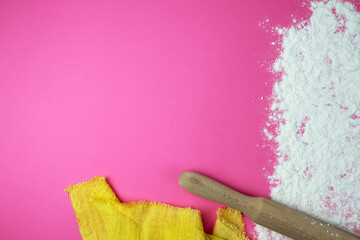 Baking background with copy space on a pink surface for your text. View from above. Flour is a traditional ingredient in bread and other baked goods. Often used in Italian, Russian, Arabic and Chinese