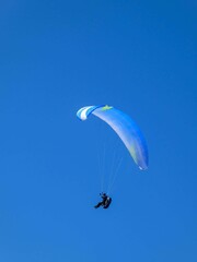 paragliding on a bright sunny day with a vivid blue sky as background