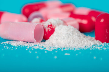 Pink capsule pills on blue background. Antibiotics drug resistance. Antimicrobial capsule pills. Pharmaceutical industry. Healthcare and drugstore. Pharmaceutics concept. Drug in hospital. 