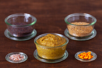 Homemade mustard sauce in glass bowl jar with ingredients.