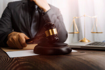 Justice and law concept.Male judge in a courtroom with the gavel, working with, computer and...