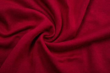 Fototapeta na wymiar Pleats on fabric, knitted material of Crimson color, folds
