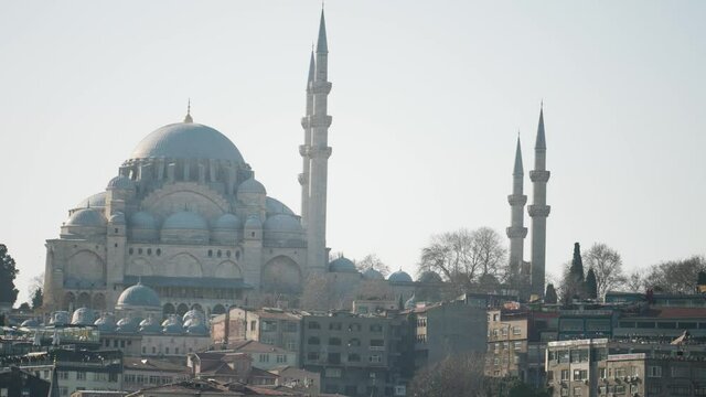Beautiful mosque towers over city. Action. Great Mosque with its minarets and blue domes stands at top of city. Beautiful view of Istanbul Mosque on clear day