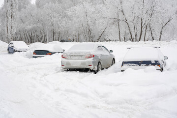 Cars covered by snow, parking in the courtyard of an apartment building after a snowstorm