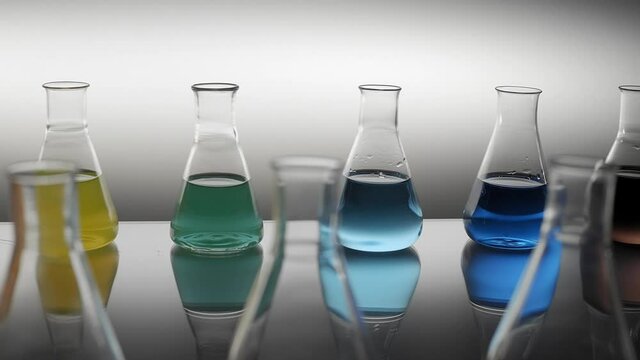 Laboratory flask filled with colored liquid reflecting on table