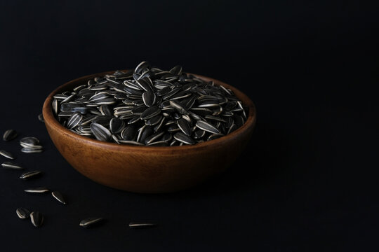 Sunflower seeds in a wooden plate. Healthy food concept.
