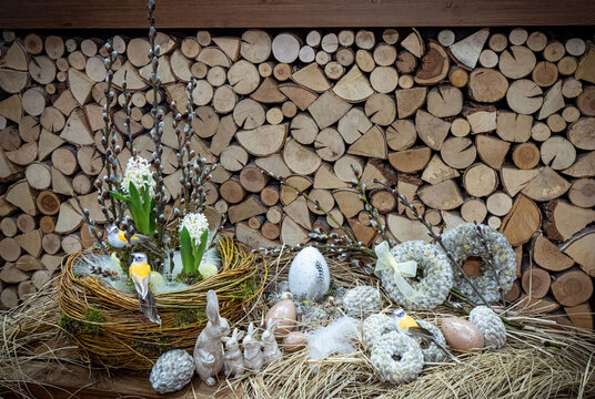 Easter bouquet composition with colorful eggs in nest on wooden background. Angement flower eco with copy space