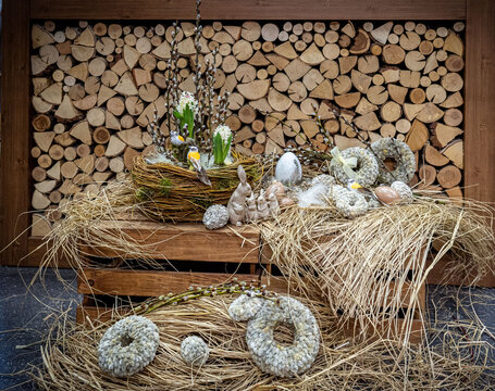 Easter bouquet composition with colorful eggs in nest on wooden background. Angement flower eco with copy space