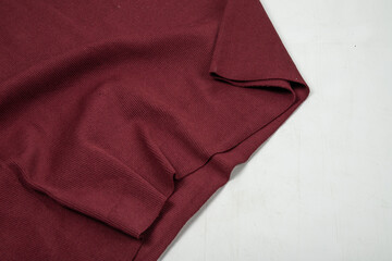 Pleats on fabric, knitted material of burgundy color, folds, knitted