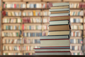 Stack of books on the table against the background of the library