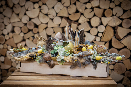 Easter bouquet composition with colorful eggs in nest on wooden background. Angement flower eco with copy space
