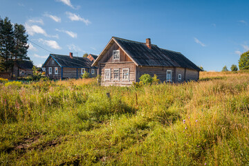 Naklejka na ściany i meble An old abandoned house in Karelian village in Russia on a sunny summer day