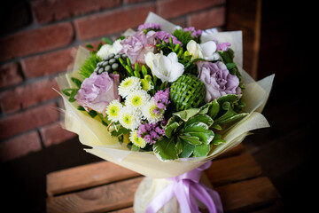 Bouquet of fresh delicate flowers on a dark shady blured background gift