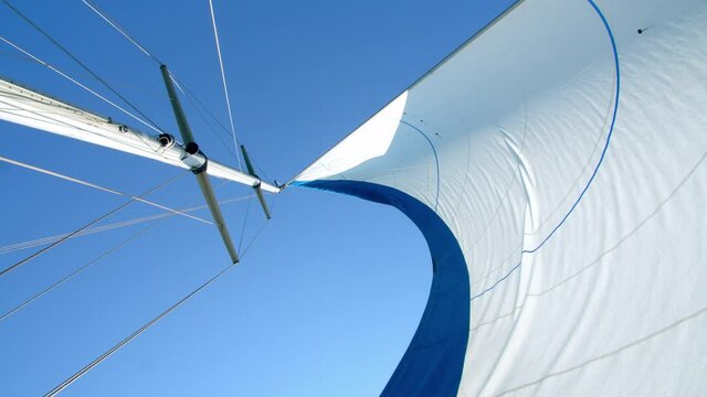 Nautical vessel. A sailboat mast and jib seen from below. 4k slow motion
