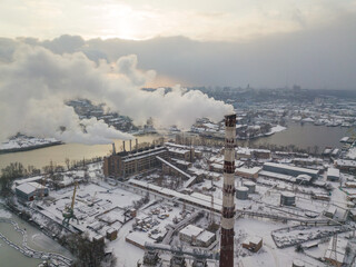 The flue pipe of the power plant. Aerial drone view. Winter snowy evening.