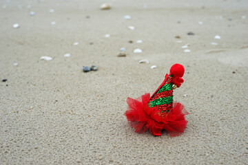 Fototapeta na wymiar Hair clip is a red hat on the beach. Fashion design hair accessories for little girls.