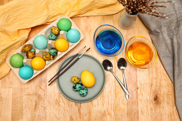 Painting eggs for Easter with liquid food dyes. Different colors in different bowls. Top view.