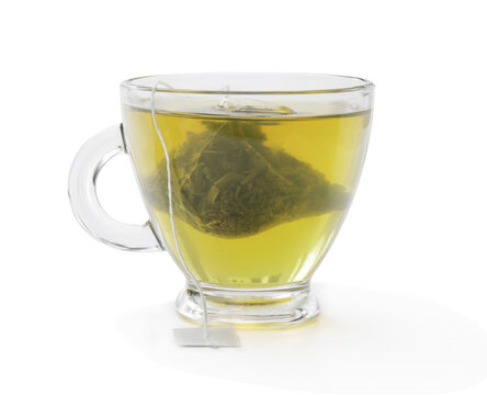 Cup of green tea with jasmine and pyramid tea bag isolated on white
