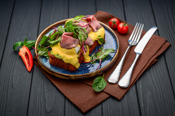 Eggs Benedict on toast with ham and sauce