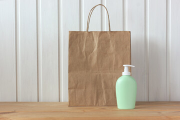 brown paper bag and a plastic bottle with a dispenser on the table.