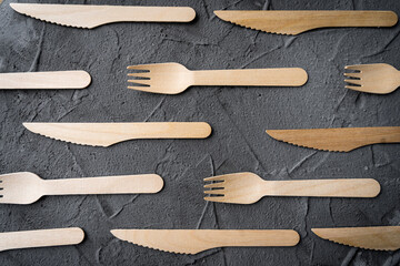 Wooden knife and fork on the black background. Eco friendly zero-waste concept. Top view with space for text. Copy space
