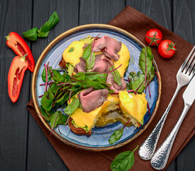 Eggs Benedict on toast with ham and sauce