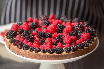 Chef cook preparing tart in his kitchen. Delicious raspberry  tart (tartlet) with whipped cream. Breakfast Buffet Concept, Breakfast Timeю. Various brunch on the table
