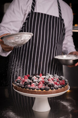 Chef cook preparing tart in his kitchen. Delicious raspberry  tart (tartlet) with whipped cream. Breakfast Buffet Concept, Breakfast Timeю. Various brunch on the table
