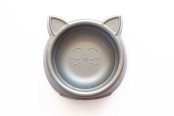 A cat food cup in the form of cat head isolated on a white background. Silver plastic bowl with water