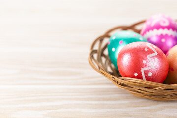 Five easter eggs trendy colored deep blue, green, orange, magenta and golden decorated in basket on white background. Copy space for text.