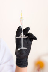 Hand with a syringe for injections lip augmentation in a beauty clinic close up